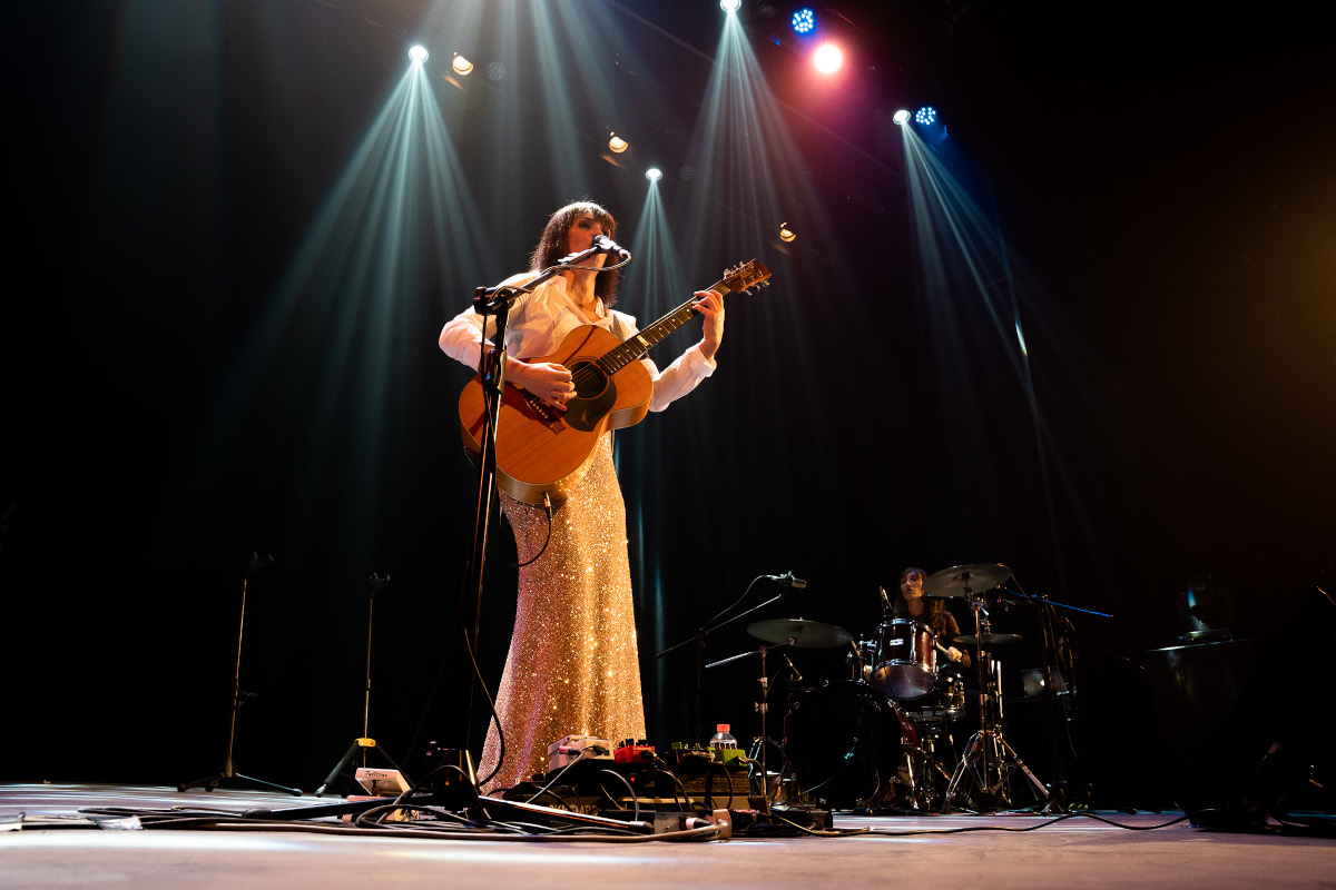 Foto della cantante Carmen Consoli che canta e suona la chitarra sul palcoscenico del Teatro Pirandello